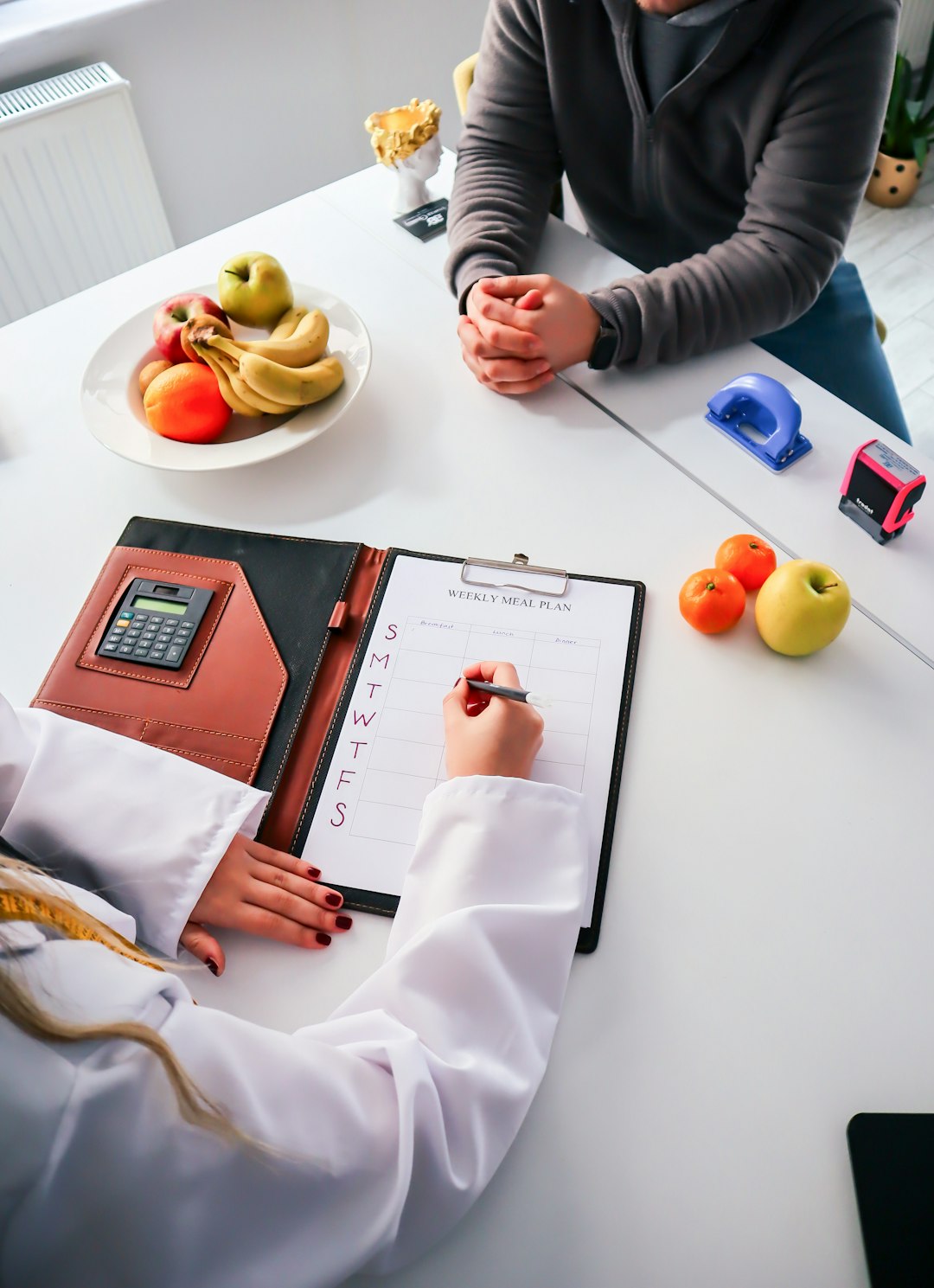 two-people-sitting-at-a-table-writing-on-a-clipboard-66eedpb6ekg